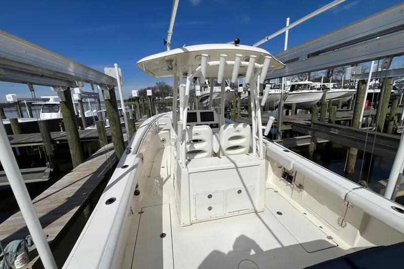 Slide: The Image of 2020 Cobia 301 Center Console boat docked at marina under clear blue sky. - 7