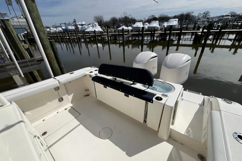 Slide: The Image of 2020 Cobia 301 Center Console boat docked at marina with twin engines. - 9