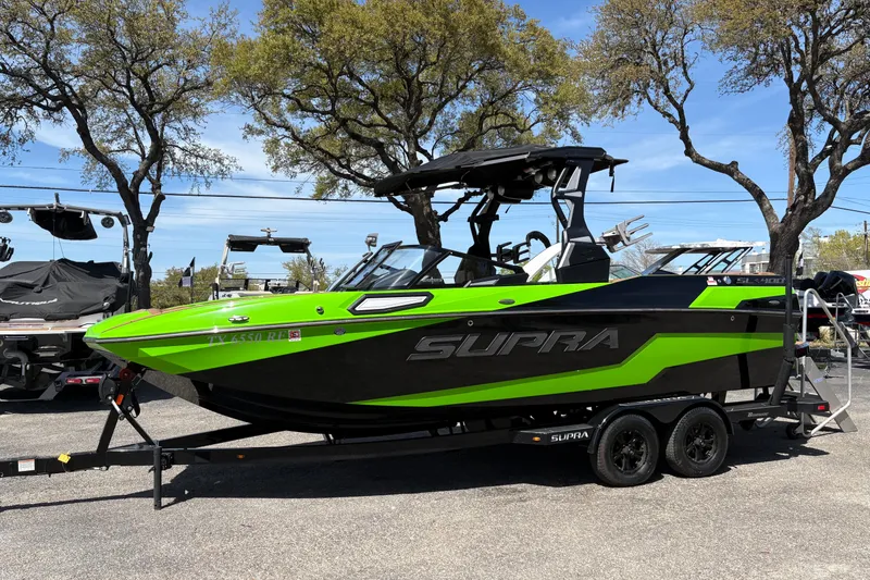 The Image of 2023 Supra SL 400 boat in vibrant green and black on a trailer. - 1