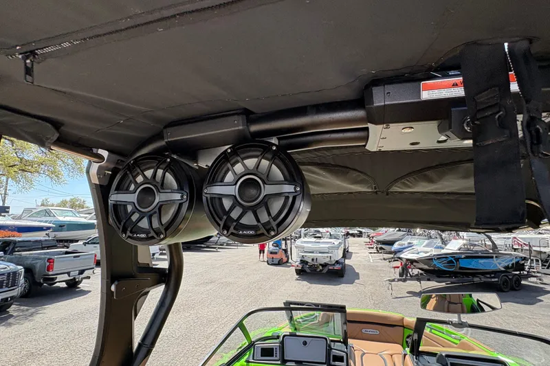 Slide: The Image of 2023 Supra SL 400 boat with JL Audio speakers, docked among other boats. - 15