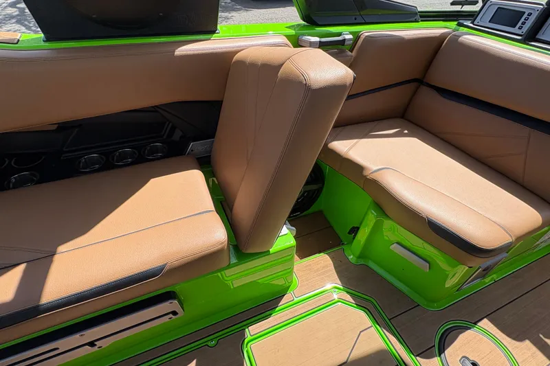 Slide: The Image of 2023 Supra SL 400 boat interior with tan leather seats and vibrant green accents. - 18