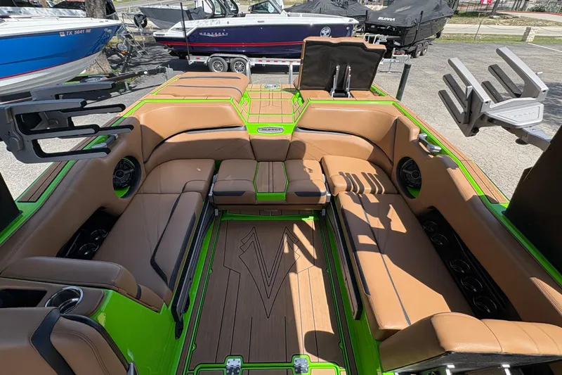 Slide: The Image of 2023 Supra SL 400 boat interior with tan seating and green accents. - 19