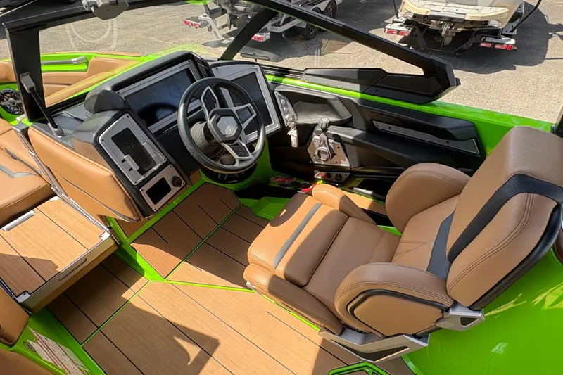 Slide: The Image of Interior of a 2023 Supra SL 400 boat with green accents and tan seating. - 20