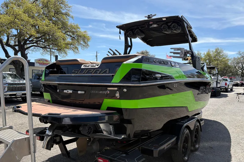 Slide: The Image of 2023 Supra SL 400 boat with vibrant green accents on a trailer in a sunny outdoor setting. - 7
