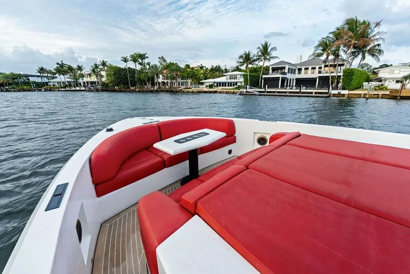 Slide: The Image of Luxurious 2016 Vanquish Yachts VQ48 with red seating, cruising near waterfront homes. - 20