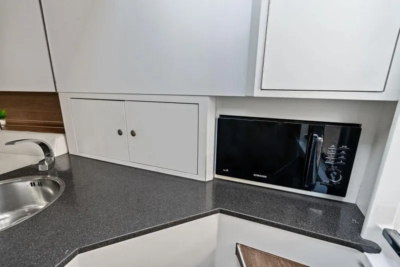 Slide: The Image of Modern kitchen area in 2016 Vanquish Yachts VQ48 with microwave and sink. - 23