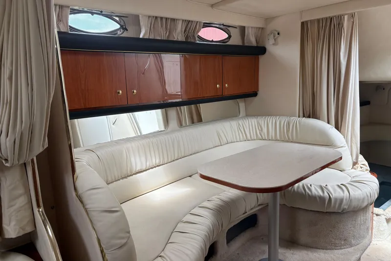 Slide: The Image of Interior of 2000 Sea Ray 340 Sundancer with white leather seating and wooden cabinets. - 17