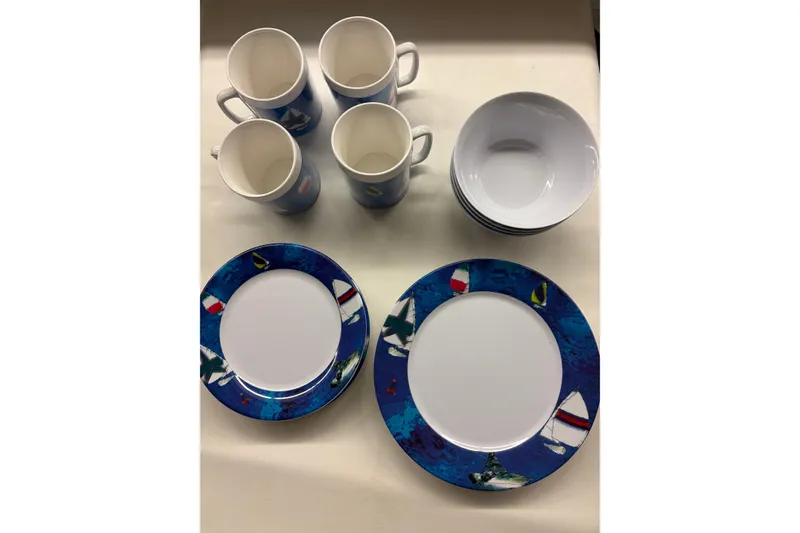 Slide: The Image of Ceramic dinnerware set with nautical-themed plates, mugs, and bowls on display. - 25