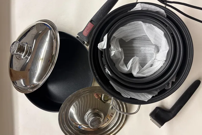 Slide: The Image of Cookware set with lids and detachable handle on a white surface. - 27