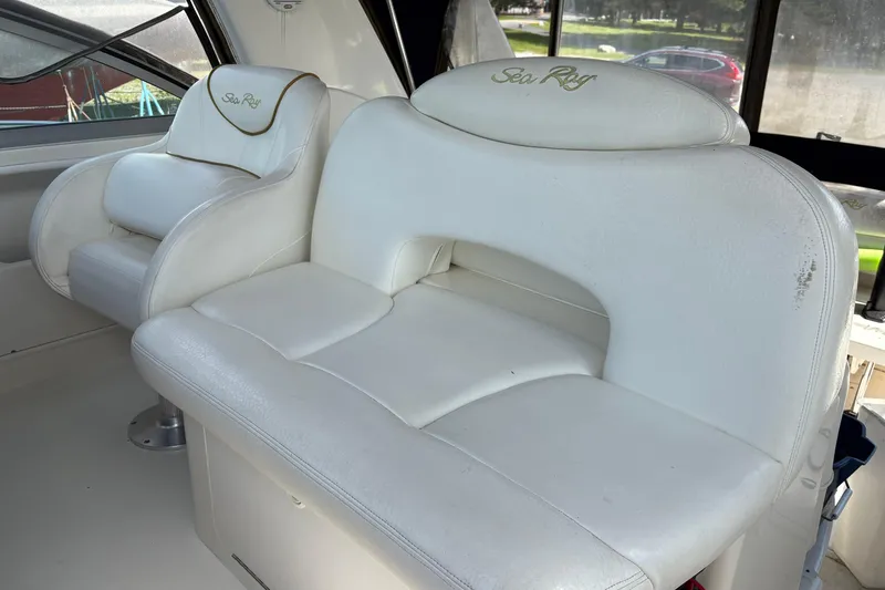 Slide: The Image of Interior seating of 2000 Sea Ray 340 Sundancer boat, featuring white leather upholstery. - 4