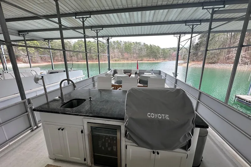 Slide: The Image of Covered deck of 1997 Lazy Days 16x85 houseboat with outdoor kitchen and scenic lake view. - 17