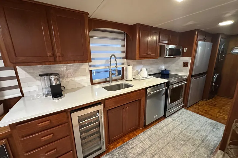 Slide: The Image of Modern kitchen in a 1997 Lazy Days 16x85 houseboat with wooden cabinets and stainless steel appliances. - 5