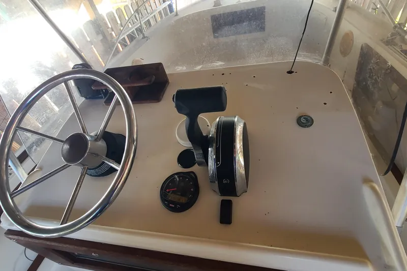 Slide: The Image of 1983 Mako 20 Center Console boat dashboard with steering wheel and controls. - 14