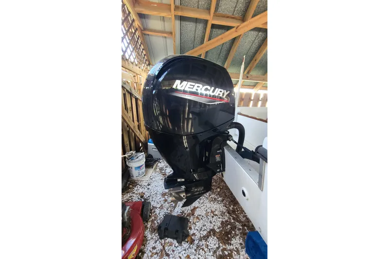 Slide: The Image of 1983 Mako 20 Center Console with Mercury outboard motor in a wooden shed. - 17