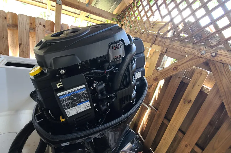 Slide: The Image of Outboard motor on a 1983 Mako 20 Center Console boat, wooden fence background. - 19
