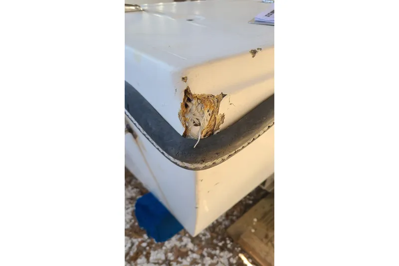 Slide: The Image of Damaged corner of 1983 Mako 20 Center Console boat with exposed fiberglass. - 22