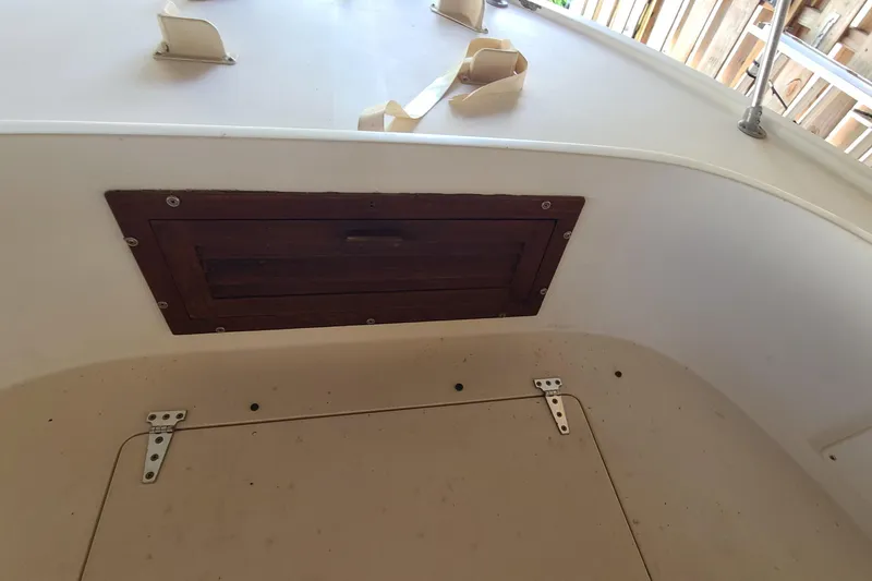 Slide: The Image of 1983 Mako 20 Center Console boat interior with wooden hatch and storage compartment. - 3