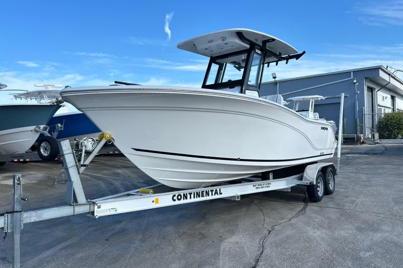 The Image of 2026 Sea Fox 228 Commander boat on trailer, parked outdoors under blue sky. - 0