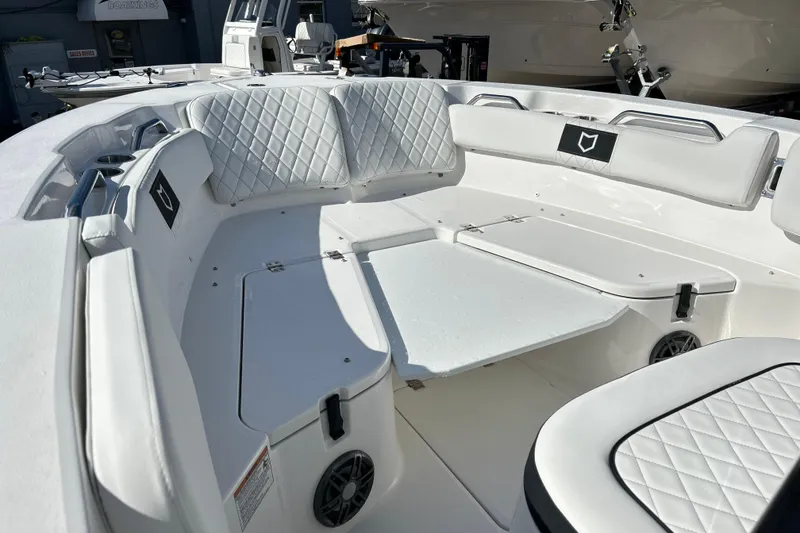 Slide: The Image of 2026 Sea Fox 228 Commander boat interior with white quilted seating and storage compartments. - 2