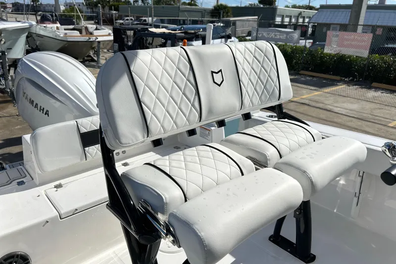 Slide: The Image of 2026 Sea Fox 228 Commander boat seats with diamond stitching, parked outdoors. - 6