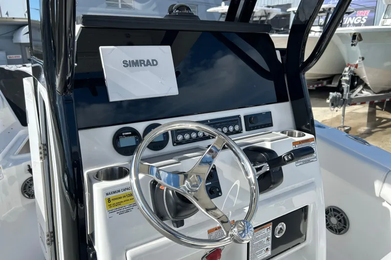Slide: The Image of 2026 Sea Fox 228 Commander boat dashboard with Simrad display and steering wheel. - 7