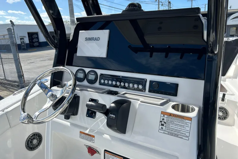 Slide: The Image of 2026 Sea Fox 228 Commander boat dashboard with Simrad display and steering wheel. - 8