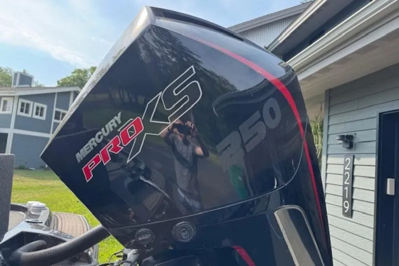 Slide: The Image of Mercury Pro XS 250 engine on a 2022 Nitro Z21 XL boat, parked near a house. - 4