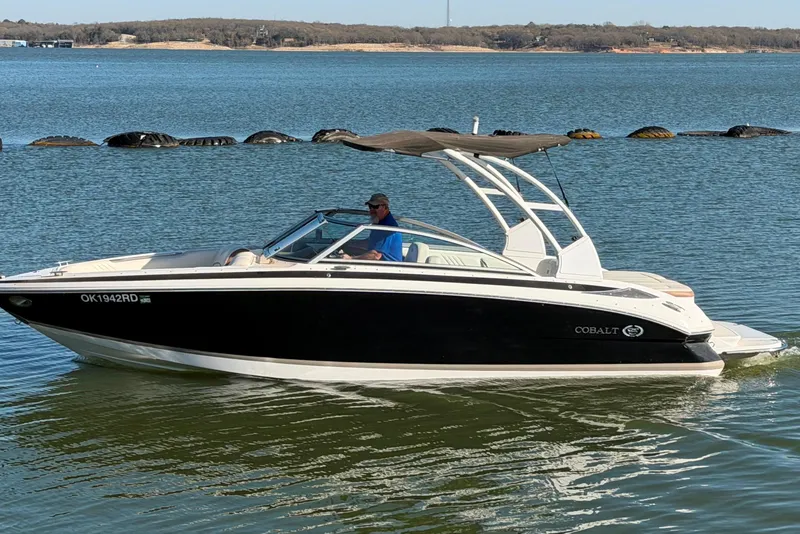 The Image of 2013 Cobalt 232 boat cruising on a serene lake with scenic background. - 0
