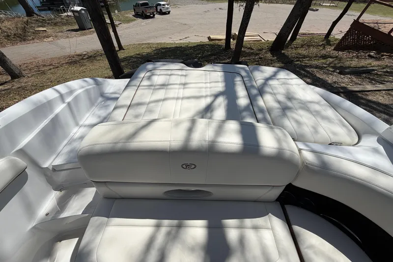 Slide: The Image of 2013 Cobalt 232 boat with white leather seating, parked near a lake. - 16