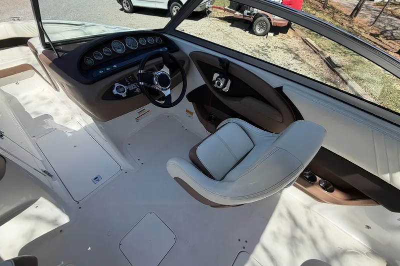 Slide: The Image of Interior of a 2013 Cobalt 232 boat featuring steering wheel and dashboard controls. - 17