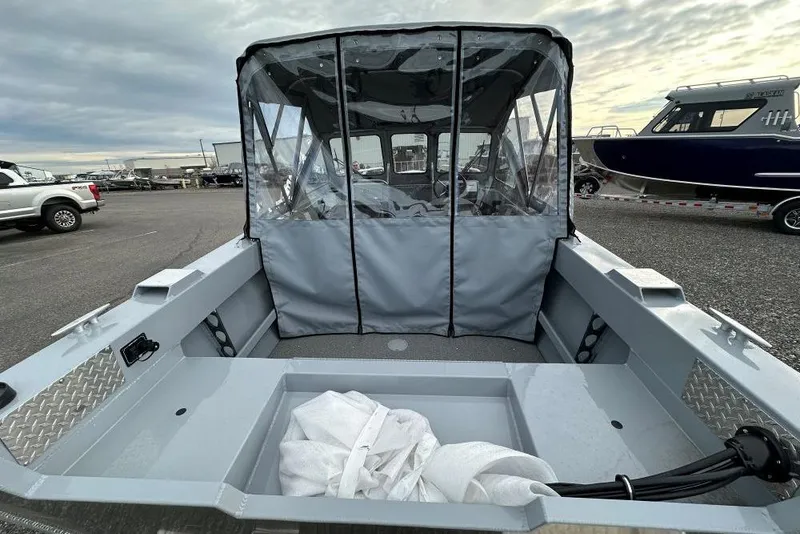Slide: The Image of 2026 Hewescraft 160 Sportsman boat with covered cockpit, parked outdoors. - 11