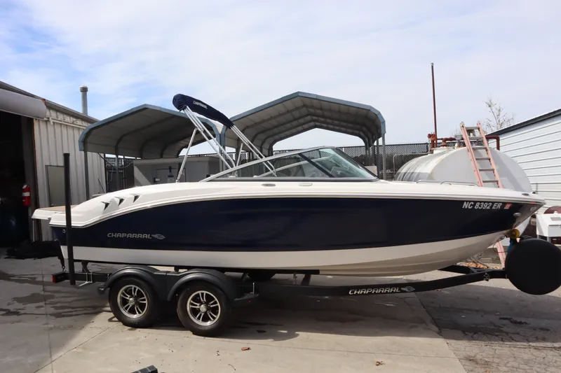 The Image of 2021 Chaparral 21 SSi boat on trailer, parked outdoors near storage facility. - 1