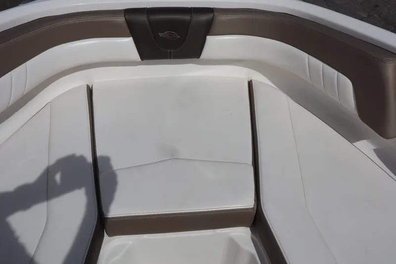 Slide: The Image of 2021 Chaparral 21 SSi boat interior with white and brown cushioned seating. - 10