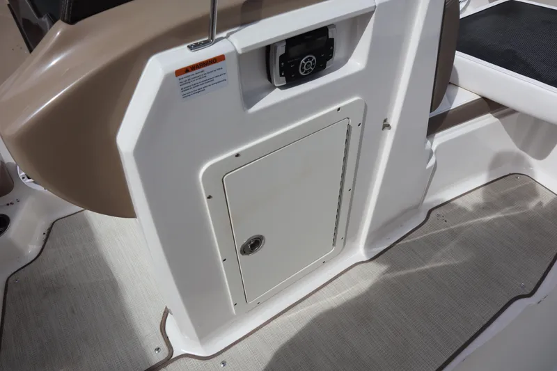 Slide: The Image of 2021 Chaparral 21 SSi boat interior with storage compartment and control panel. - 14