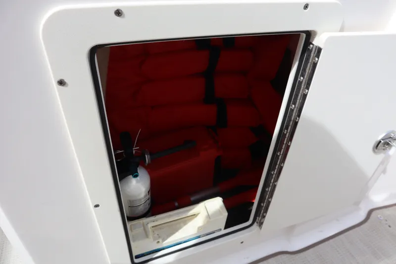 Slide: The Image of Storage compartment on a 2021 Chaparral 21 SSi boat with life jackets and fire extinguisher. - 15