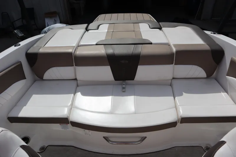 Slide: The Image of 2021 Chaparral 21 SSi boat interior with cushioned seating in white and brown tones. - 24