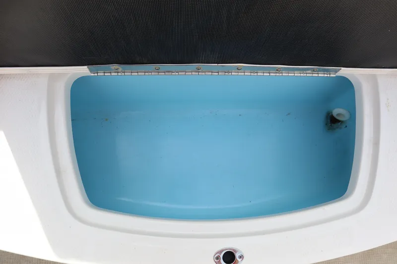 Slide: The Image of Open storage compartment in 2021 Chaparral 21 SSi boat, featuring a blue interior. - 25