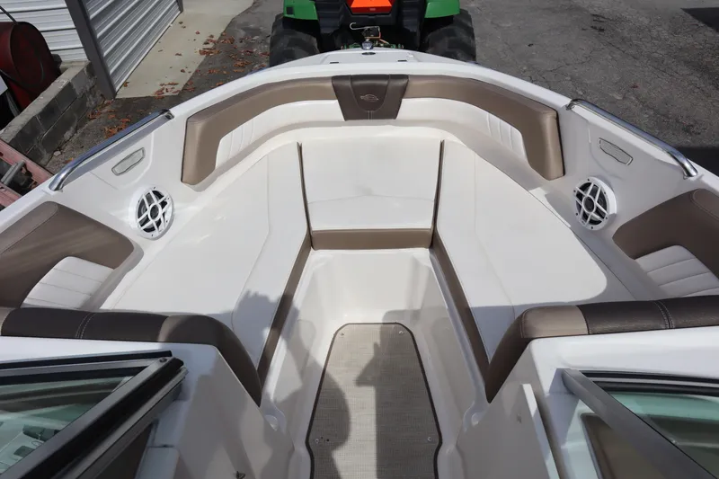 Slide: The Image of 2021 Chaparral 21 SSi boat interior with brown and white seating, featuring speakers. - 6
