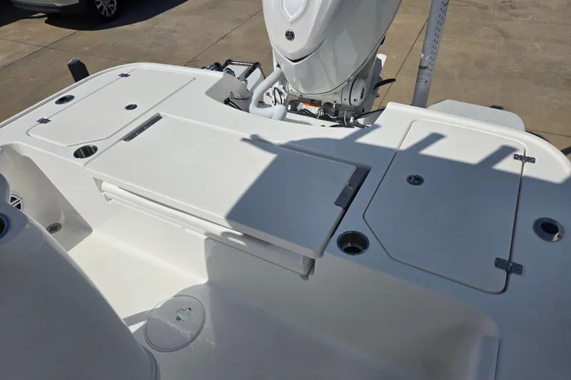 Slide: The Image of 2026 Caymas 26 HB boat deck with storage compartments and motor, showcasing sleek design. - 13