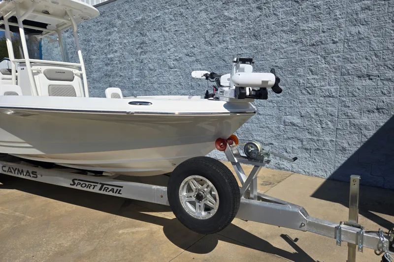 Slide: The Image of 2026 Caymas 26 HB boat on trailer, parked beside a brick wall. - 4