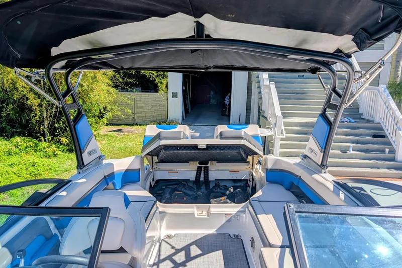 Slide: The Image of 2017 Chaparral Vortex 223 VRX boat interior with open storage compartment and blue seating. - 11