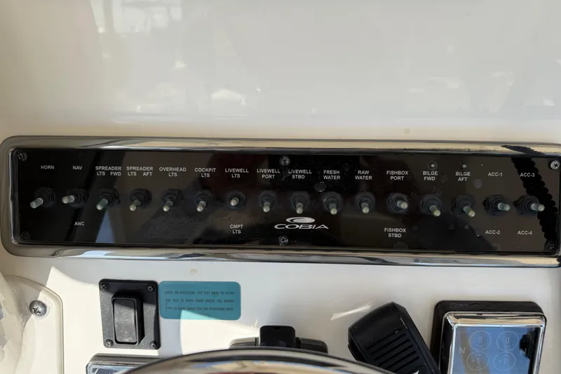 Slide: The Image of Control panel of a 2017 Cobia 296 Center Console boat with labeled switches. - 16