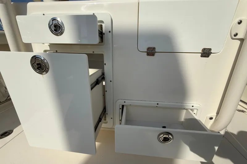 Slide: The Image of 2017 Cobia 296 Center Console storage compartments with open drawers and secure locks. - 20