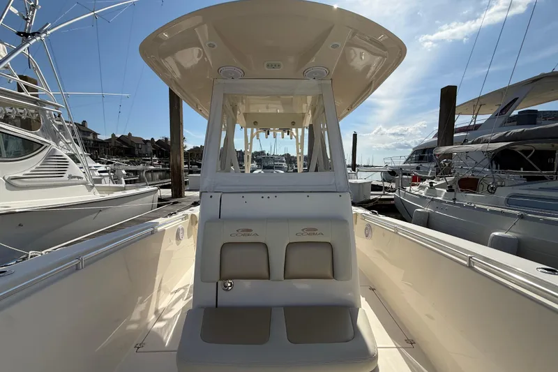 Slide: The Image of 2017 Cobia 296 Center Console boat docked at marina, showcasing seating and helm. - 25