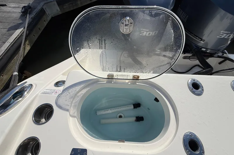 Slide: The Image of Open livewell on 2017 Cobia 296 Center Console boat with Yamaha engines. - 31