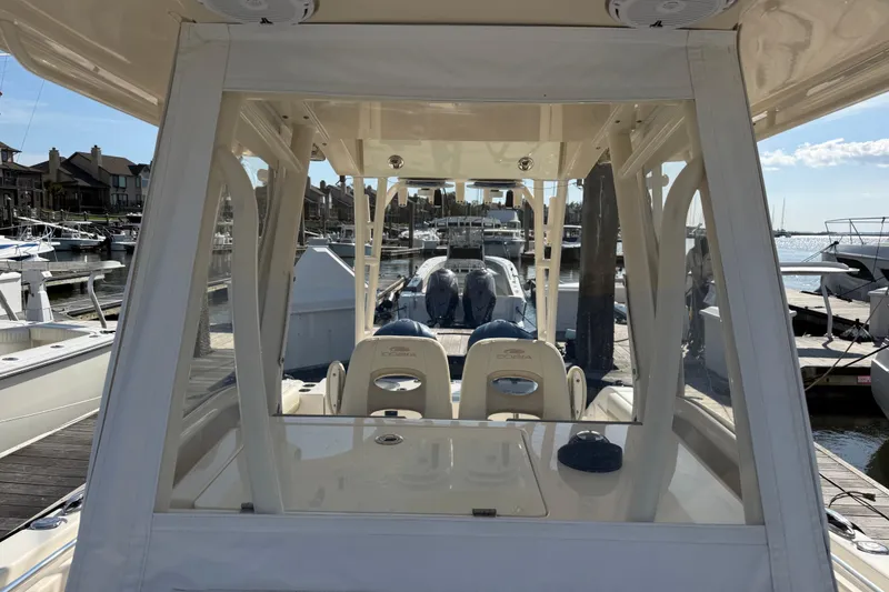 Slide: The Image of 2017 Cobia 296 Center Console boat docked at marina, showcasing helm and seating area. - 33