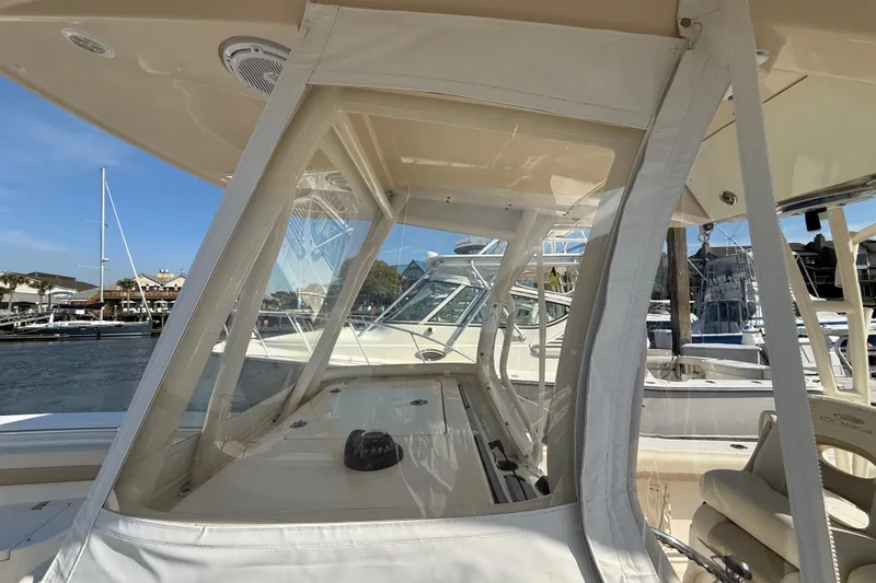 Slide: The Image of 2017 Cobia 296 Center Console boat with clear enclosure at marina. - 34