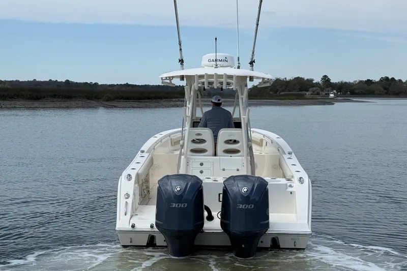 Slide: The Image of 2017 Cobia 296 Center Console boat with dual Yamaha engines on calm water. - 5