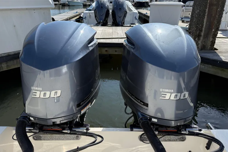 Slide: The Image of Twin Yamaha 300 engines on a 2017 Cobia 296 Center Console boat at a dock. - 6