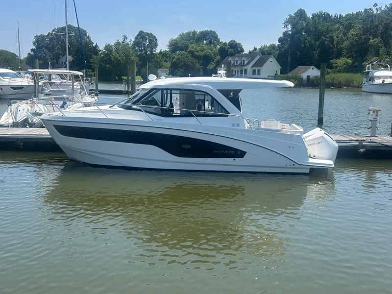 The Image of 2026 Beneteau Antares 9 V2 boat docked on a sunny day, surrounded by water and trees. - 0